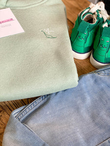 green-kids-hoodie-dino-nfm-logo-next-to-green-kids-dino-trainers-from-the-adoption-gift-range-by-notafictionalmum