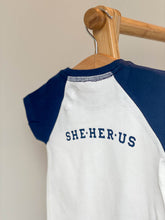 Load image into Gallery viewer, blue-white-tshirt-she-her-us-printed-on-back
