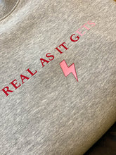 Load image into Gallery viewer, Grey-sweatshirt-close-up-slogan-Real-as-it-gets-with-pink-thunderbolt-detail
